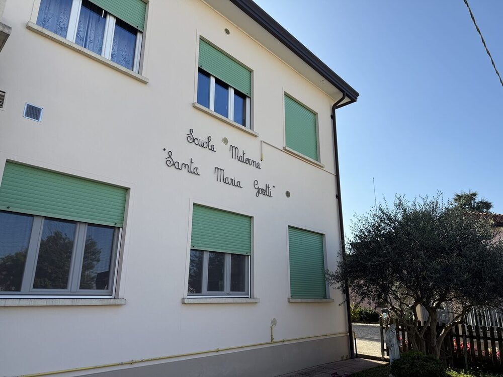 La facciata della scuola con la scritta "Scuola Materna Santa Maria Goretti"