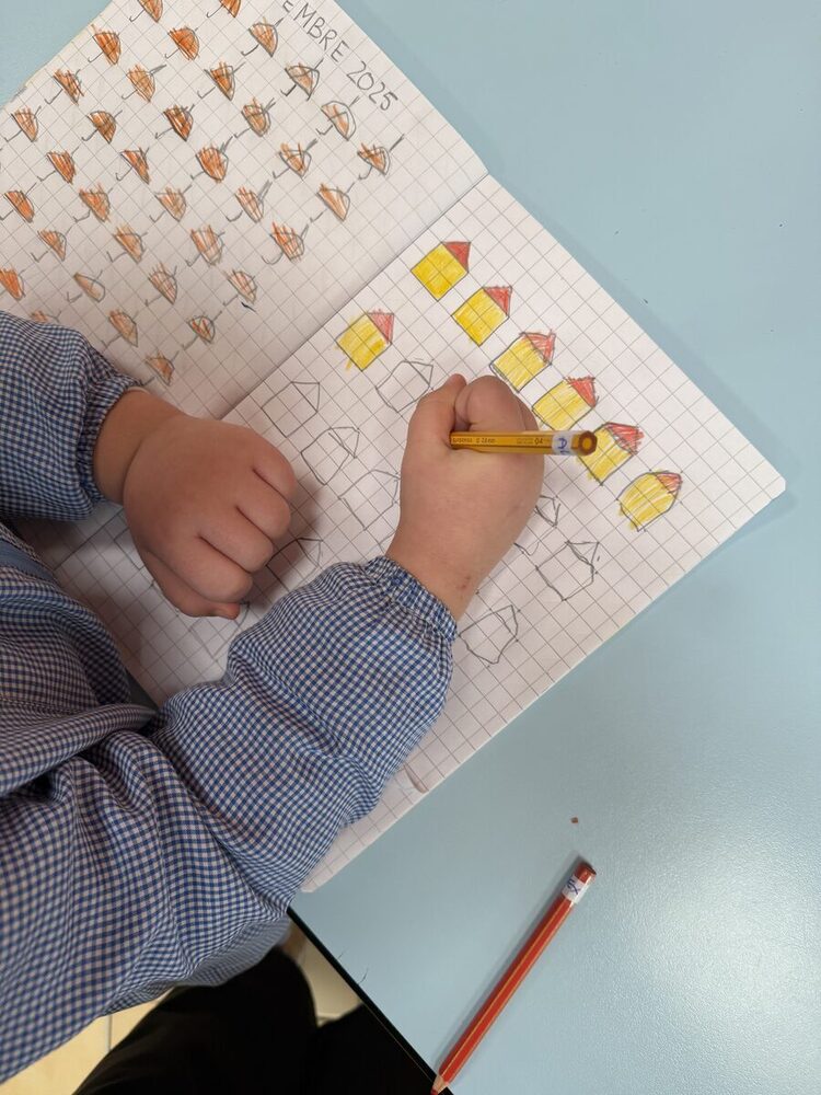 Un bambino colora il calendario del mese disegnato sul quaderno a quadretti